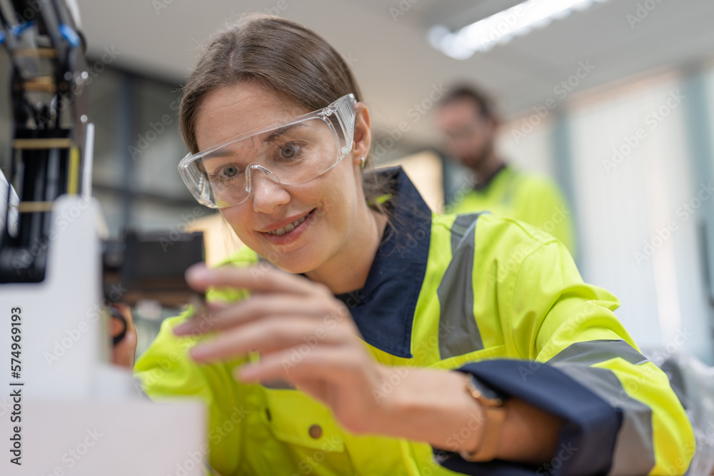 Female engineer training programmable and design AI robot arm simulation in academy robotics automation laboratory room for using in manufacturing or industry Female engineer training programmable and design AI robot arm simulation in academy robotics automation laboratory room for using in manufacturing or industry