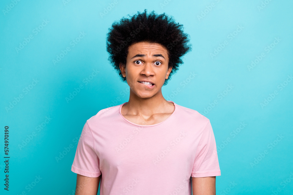 Photo of young guy funny chevelure bite lips trouble wear stylish summer pink t-shirt doubts forgot wallet isolated on aquamarine color background