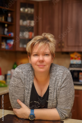 Portrait of a mature woman leaning on the worktop in the kitchen