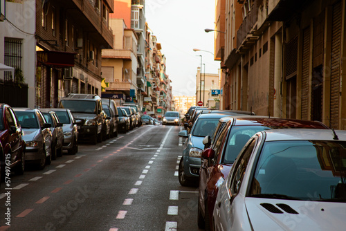 Old European street in the evening, cars parked along the street