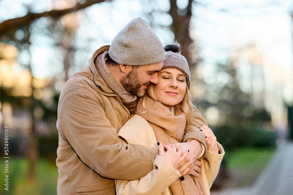 Fototapeta premium Embraced mid adult couple in the park