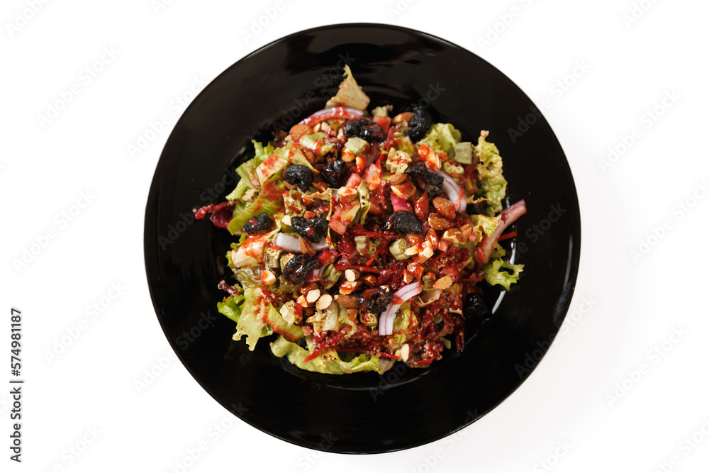 Tasty fresh salad with lettuce, onion, nuts, almond and dried plums on a black plate Tasty fresh salad with lettuce, onion, nuts, almond and dried plums on a black plate