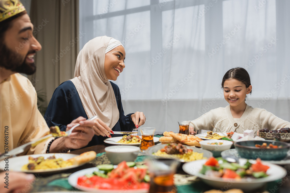 Smiling middle eastern family talking during ramadan dinner at home.