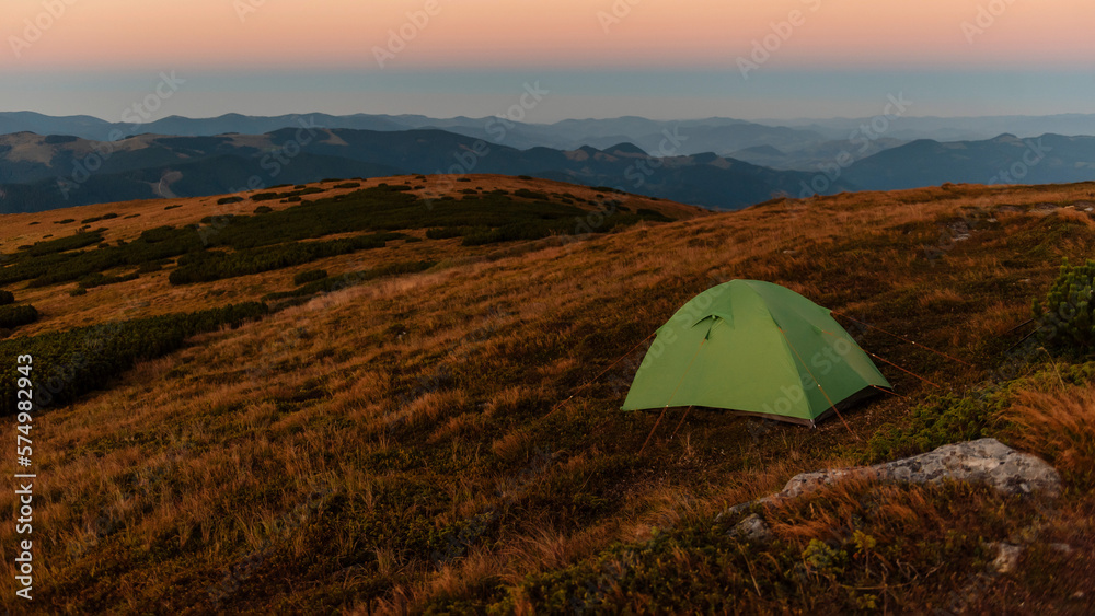Green camping tent on top of mountain