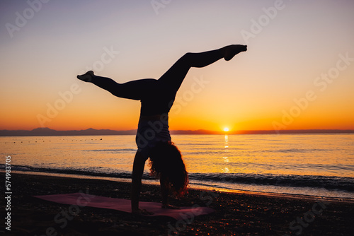 Young woman doing cartwheel near the sea