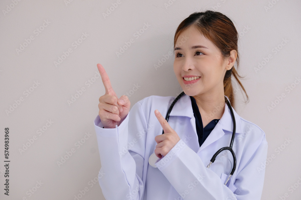 Asian doctor in white lab coat smiling pointing finger presenting on a white background. Asian doctor in white lab coat smiling pointing finger presenting on a white background.