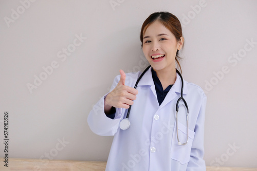 Asian female doctor wearing a white lab coat smiling on a white background.