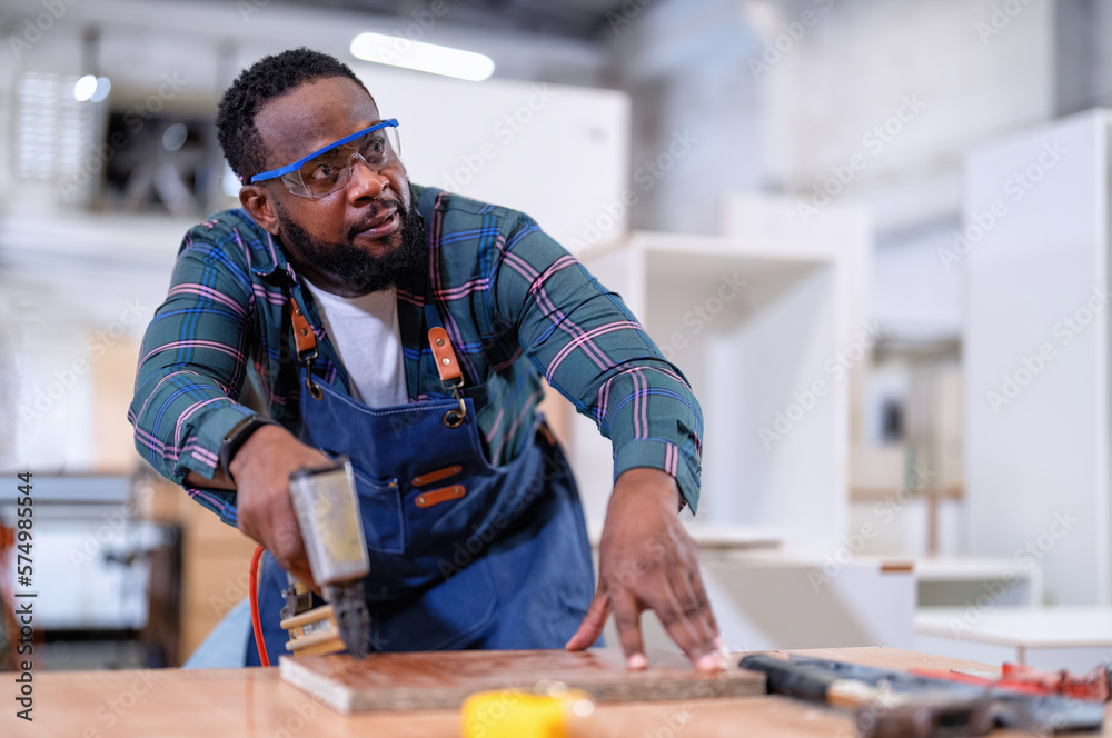 In work place carpenter man concentrate working using pneumatic nail gun drive nail to the wood In work place carpenter man concentrate working using pneumatic nail gun drive nail to the wood