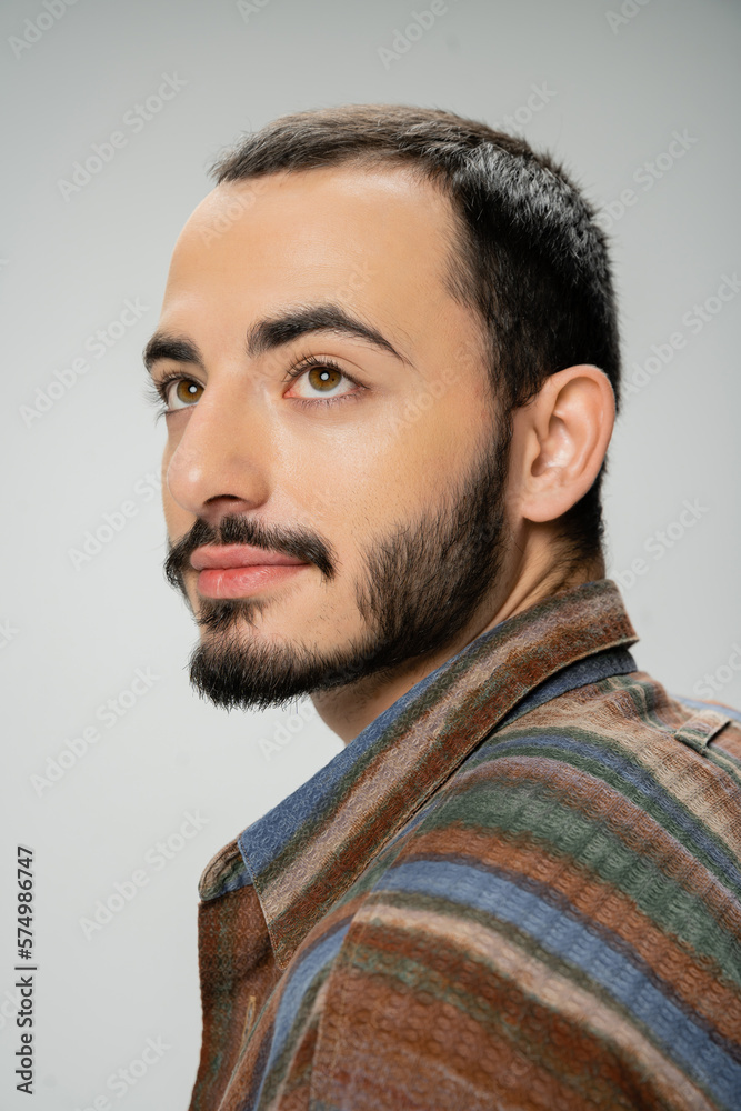 Fototapeta premium portrait of good looking bearded man in colorful shirt looking away isolated on grey.