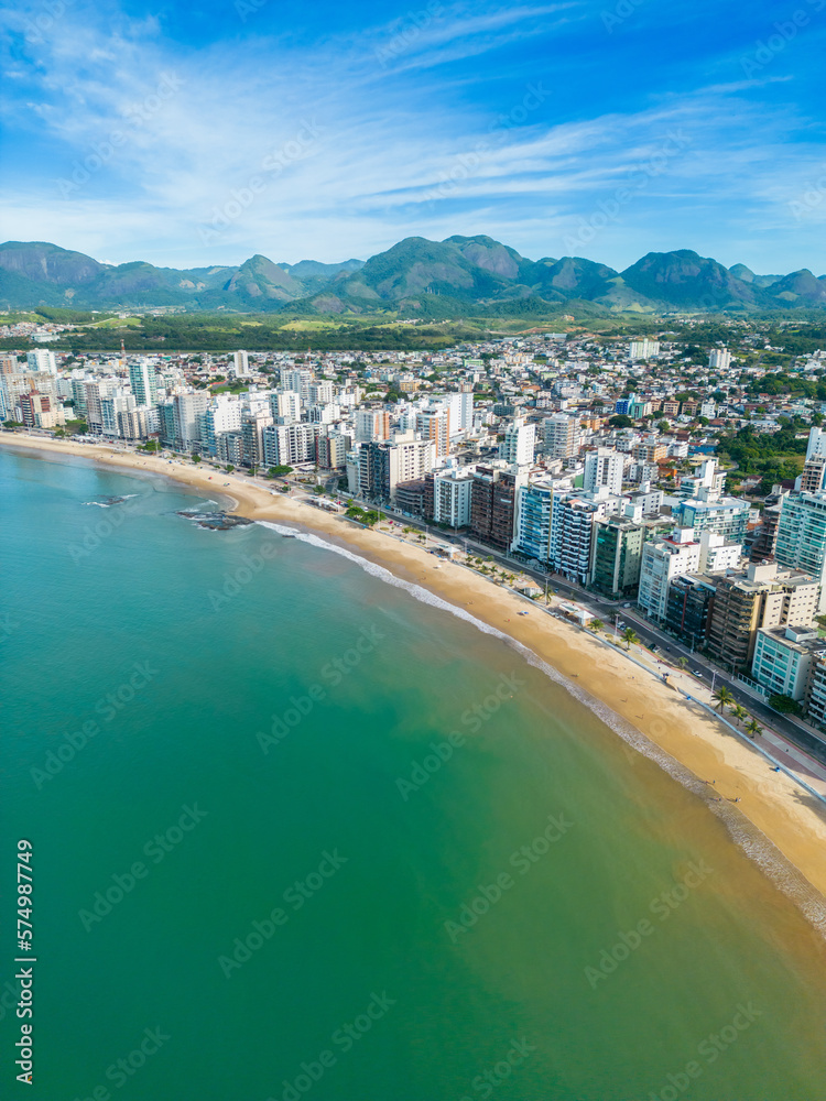 Obraz premium Imagem aérea da Praia do Morro e Praia da Cerca, na região central de Guarapari. Esportes na praia e na água como canoa havaiana e corrida.