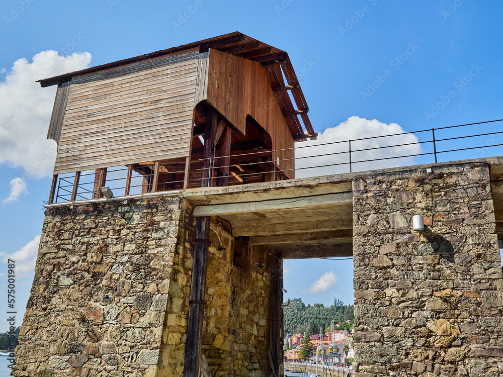 Obraz premium Coal loader in the old harbor of San Esteban de Pravia in a sunny summer day. Muros de Nalon, Asturias, Spain, Europe