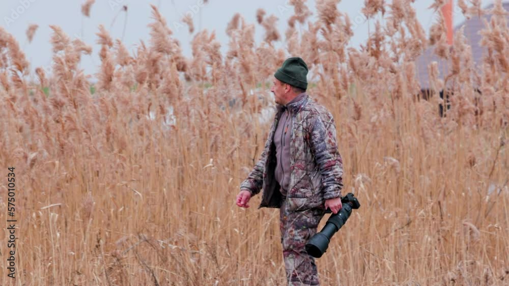 professional wildlife photographer in camouflage in action (slow motion 4k) professional wildlife photographer in camouflage in action (slow motion 4k)