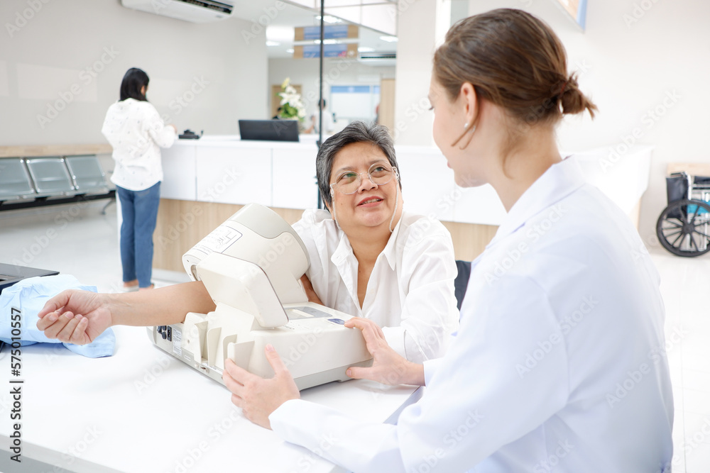 Obraz premium Female doctor measuring blood pressure, old woman patient, medical concept.