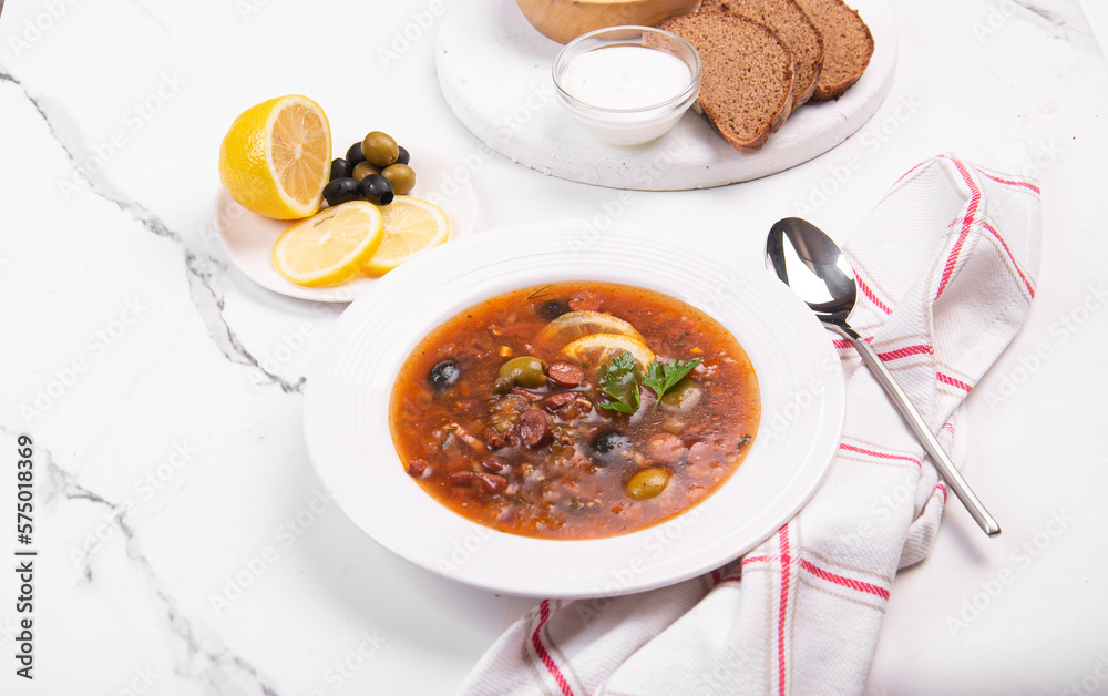 Tomato soup with olives and sausages in a white plate Tomato soup with olives and sausages in a white plate