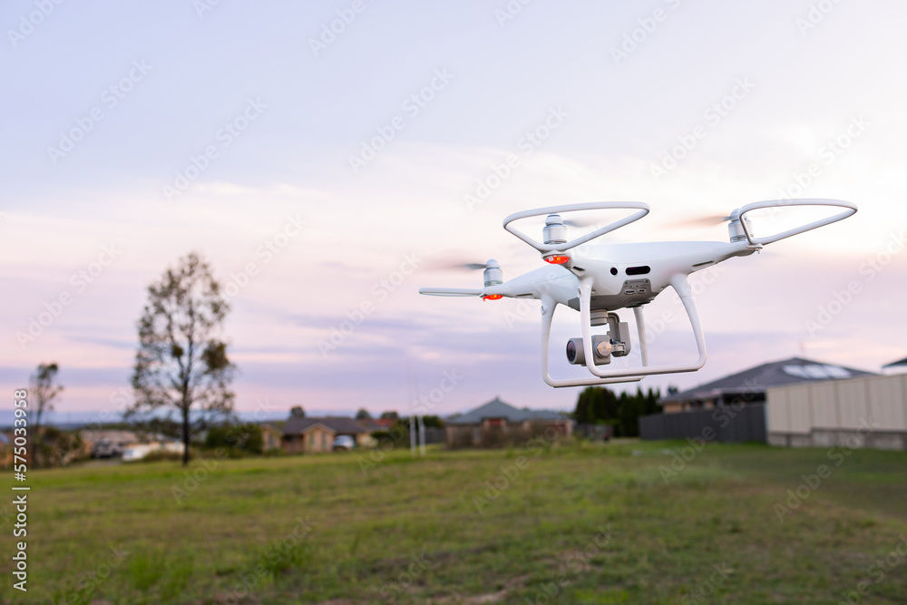 RPA drone flying over edge of suburban area at dusk RPA drone flying over edge of suburban area at dusk