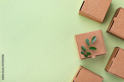 Eco, zero waste, plastic free and saving energy minimal concept from sprout with grean leaves growing from recycled cardboard box top view.