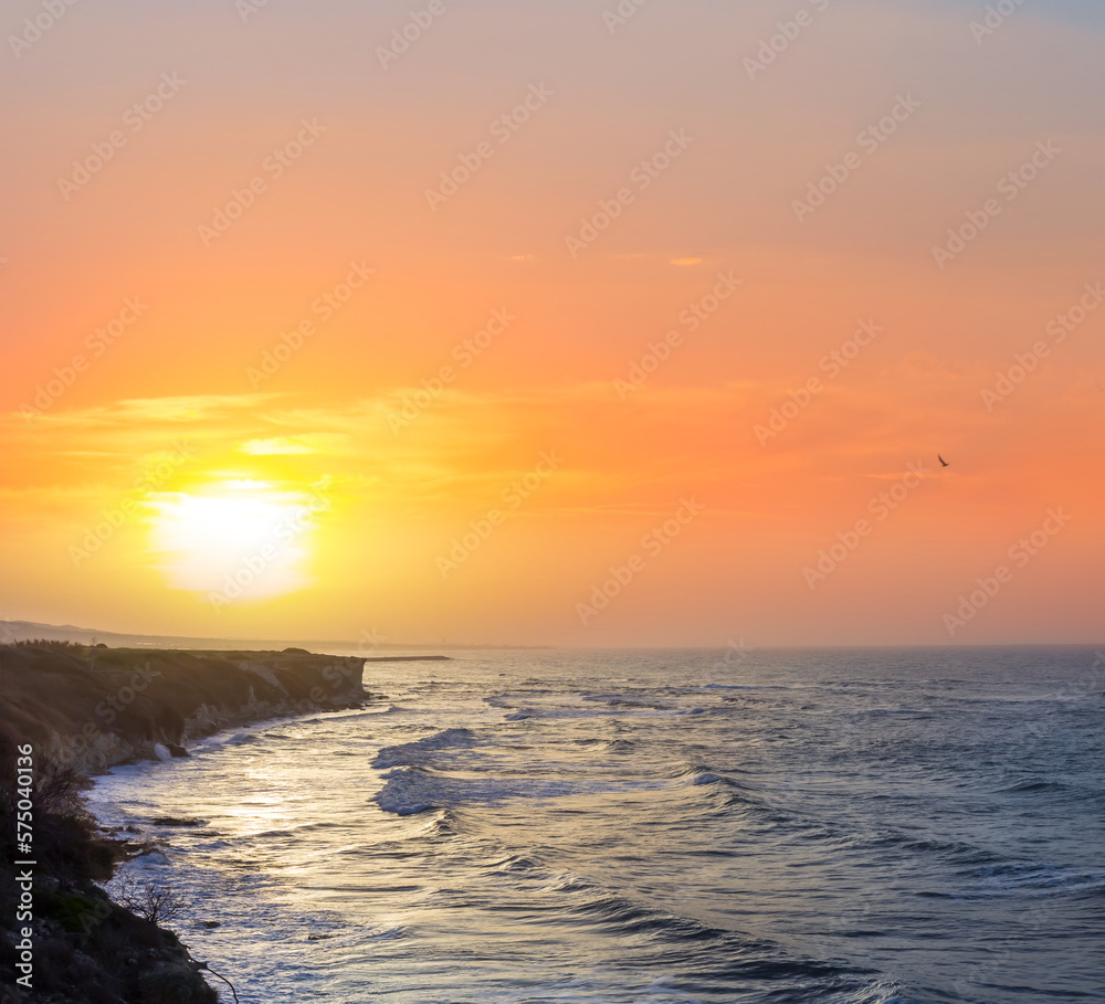 Fototapeta premium sea cape silhouette above quiet sea bay at the red dramatic sunset