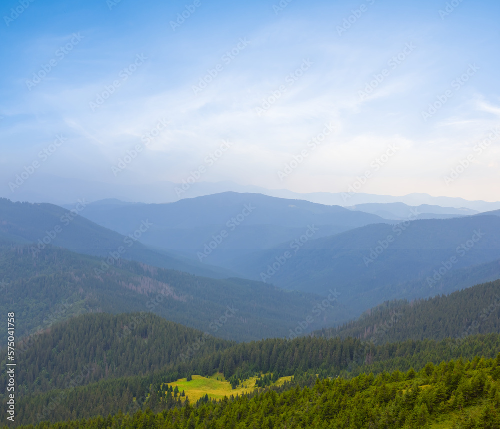 Naklejka premium mountain valley in blue mist at the early morning, summer moutain travel background