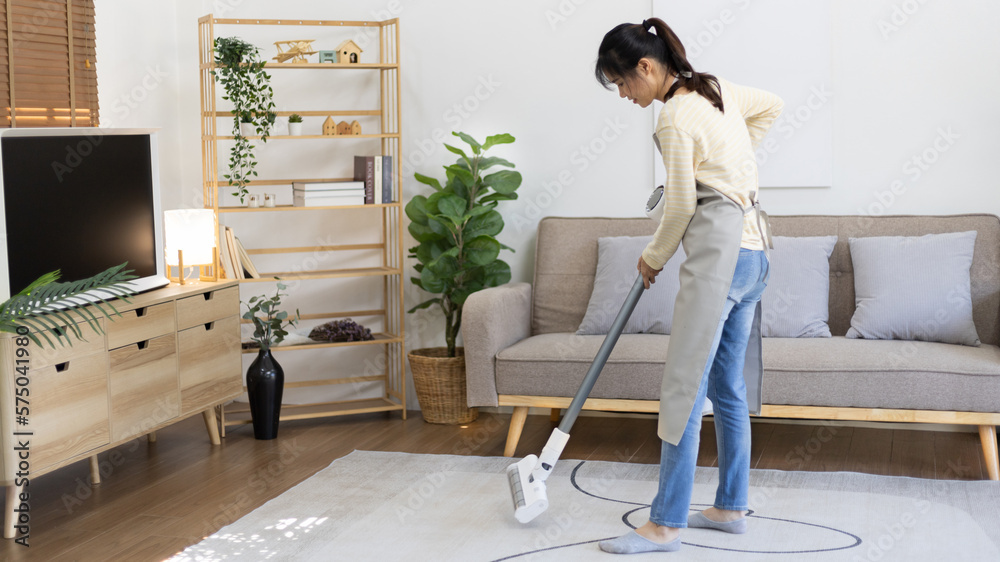 Beautiful woman vacuuming the floor and carpet in her living room, Big cleaning in the house, Removes germs, Housewife cleaning, Keeping her home clean, Domestic hygiene.