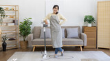 Beautiful housewife standing next to a vacuum cleaner and ready to do a big house cleaning job, Big cleaning in the house, Removes germs and dirt and deep stains, Housewife cleaning, Domestic hygiene.