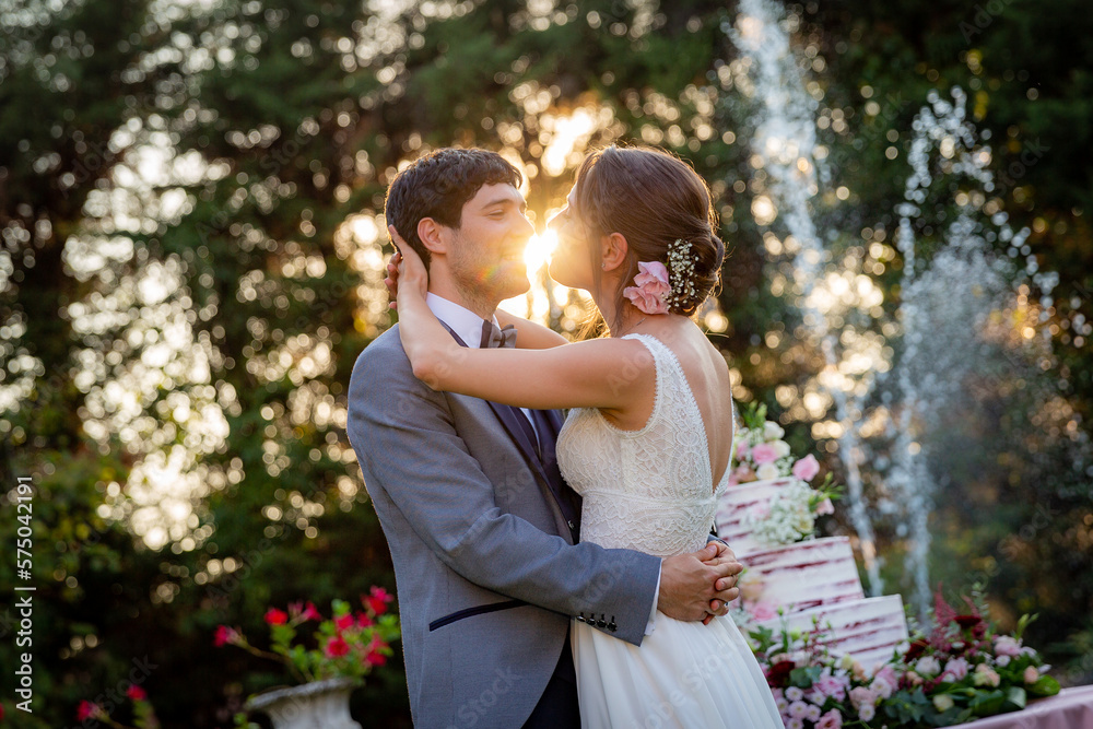 Fototapeta premium Husband and wife embracing on their wedding day at sunset