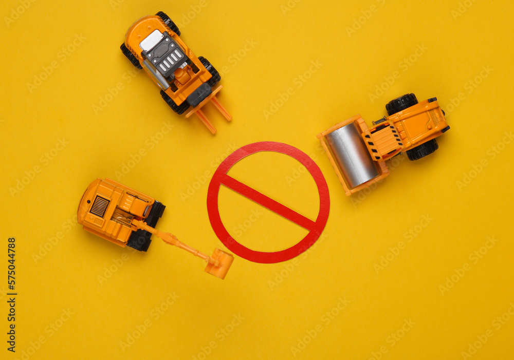 Obraz premium Toy heavy machinery with a prohibition sign on yellow background. Top view