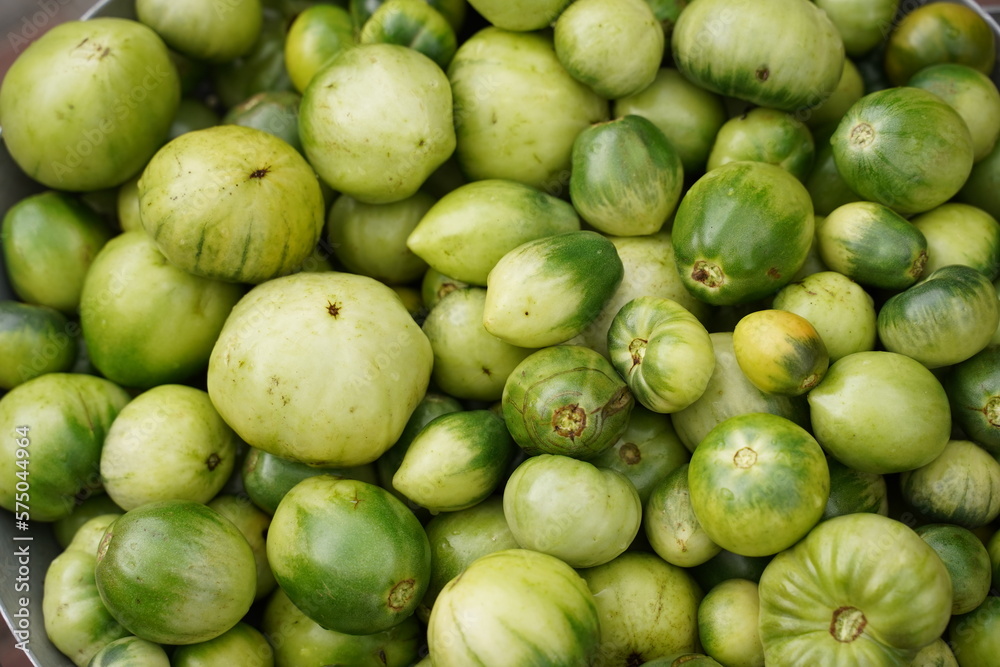 Green unripe tomatoes in an iron bucket. Top view Green unripe tomatoes in an iron bucket. Top view