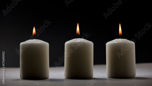 three burning candles on white table with black background, space for text
