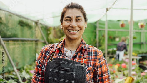 Foto Happy Hispanic woman working in flower garden shop