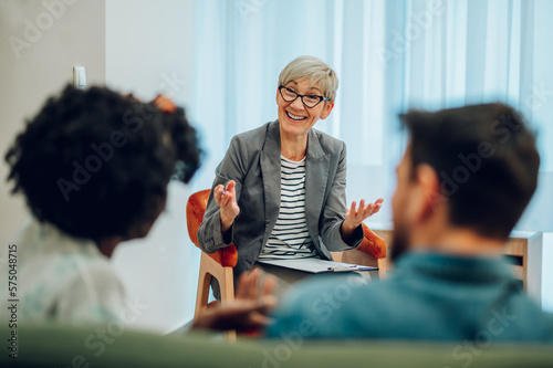 Senior woman psychiatrist talking with her patients during therapy session