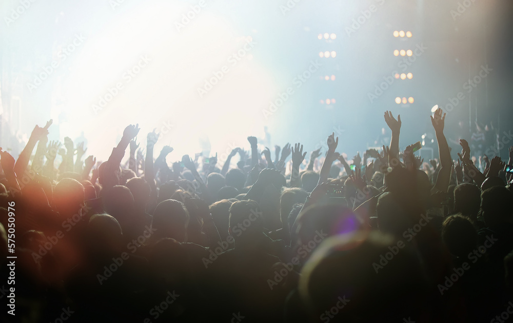 Group of fans partying on rock concert in night club. Bright festival background with cheerful young people on the dance floor