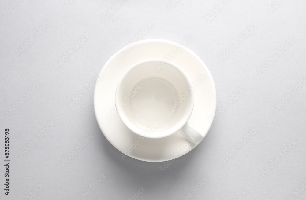 Empty ceramic cup with saucer on gray background. Top view Empty ceramic cup with saucer on gray background. Top view