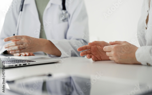 Doctor and patient discussing current health examination while sitting at the desk in clinic office  closeup. Perfect medical service and medicine concept.