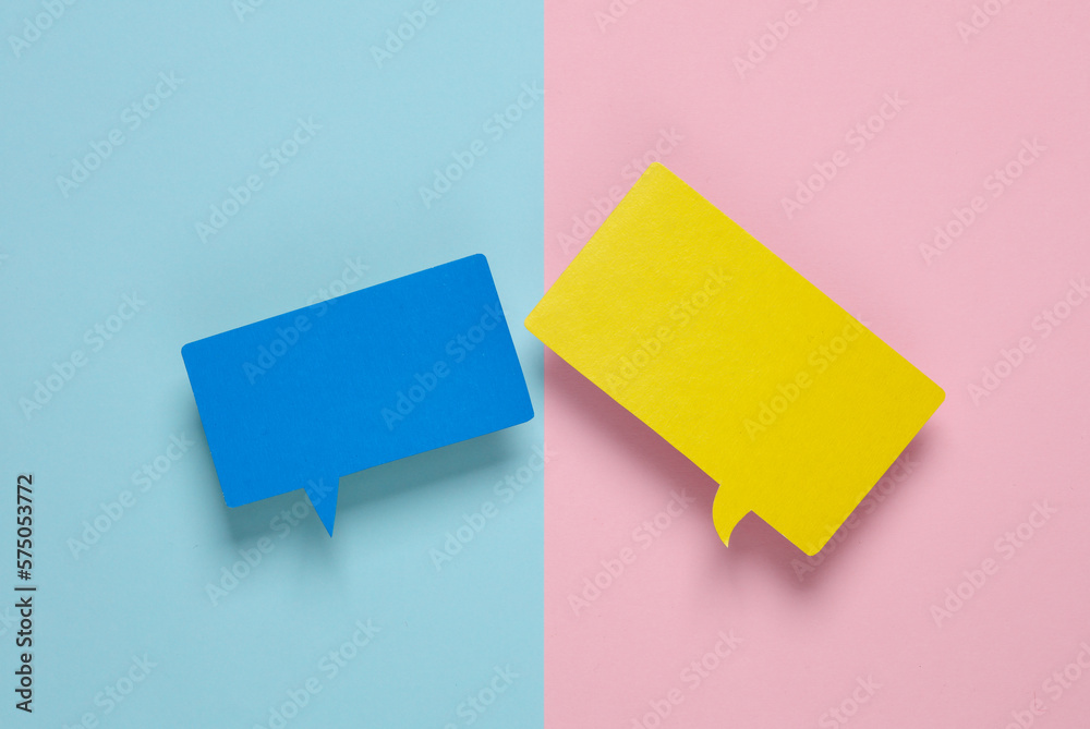 Different colors blank paper-cut speech bubbles on pink blue background. Chat, social media, discussion. Mock up for template design. Top view Different colors blank paper-cut speech bubbles on pink blue background. Chat, social media, discussion. Mock up for template design. Top view