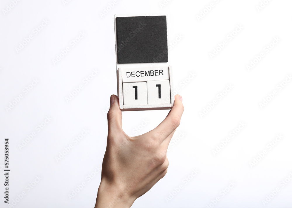 Female hand holding wooden calendar with date december 11 isolated on white background Female hand holding wooden calendar with date december 11 isolated on white background