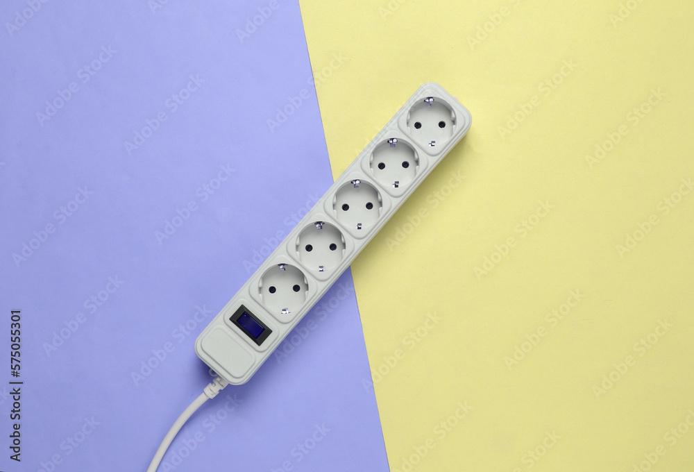Electrical Extension cord on a blue-yellow pastel background. Top view. Flat lay Electrical Extension cord on a blue-yellow pastel background. Top view. Flat lay