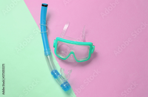 Diving mask with snorkel on pink blue background. Top view