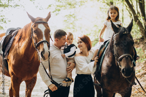 Young family with kids having fun with horse in forest © Petro