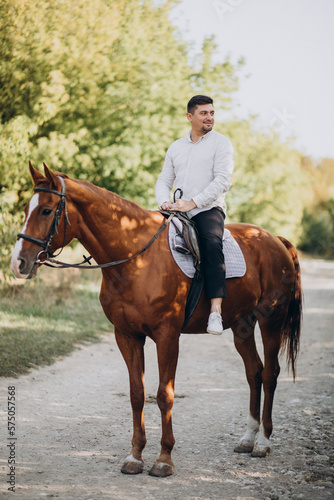 Handsome man riding a horse in forest © Petro