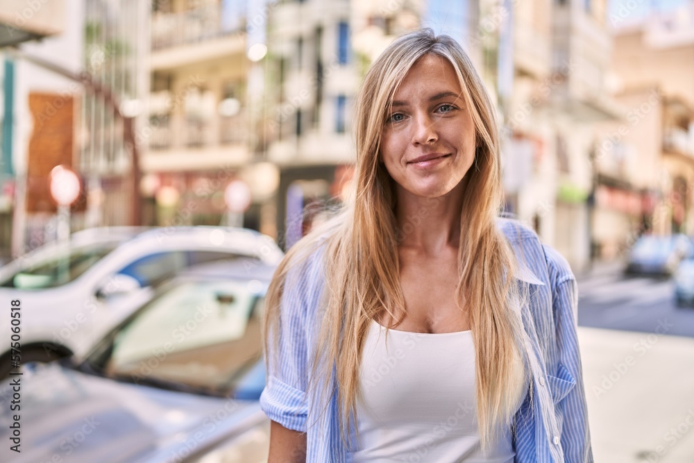 Fototapeta premium Young blonde woman smiling confident standing at street