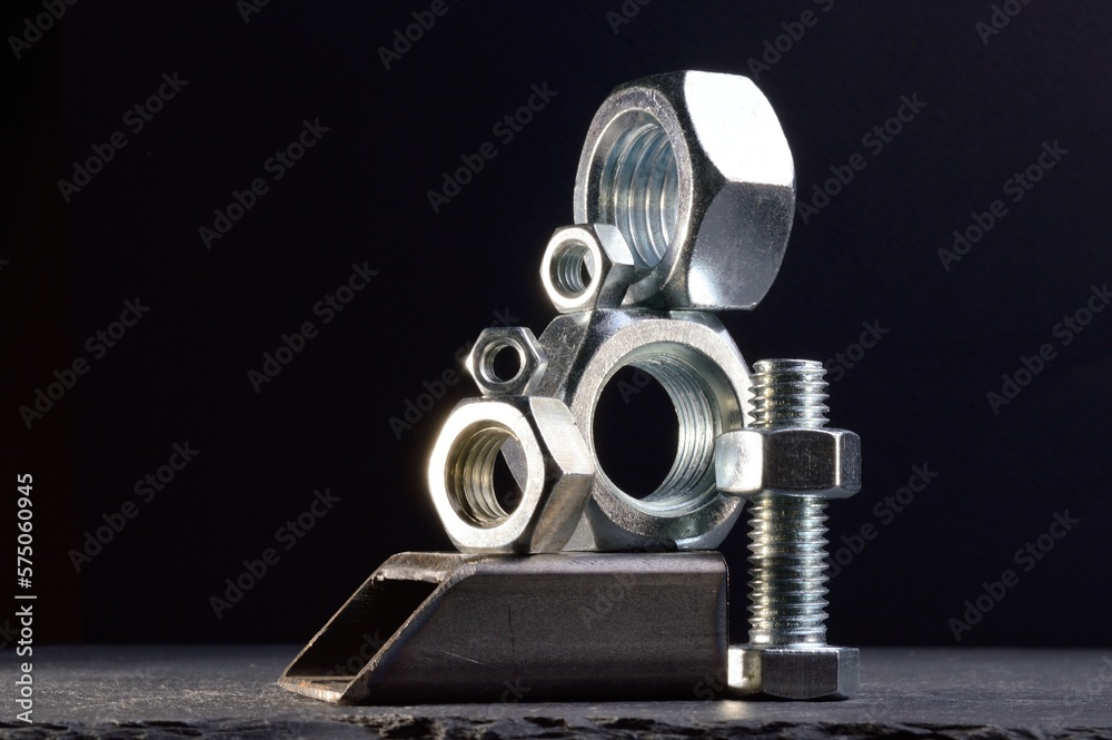 composition of nuts bolts and scraps of metal laid out on a dark background. composition of nuts bolts and scraps of metal laid out on a dark background.