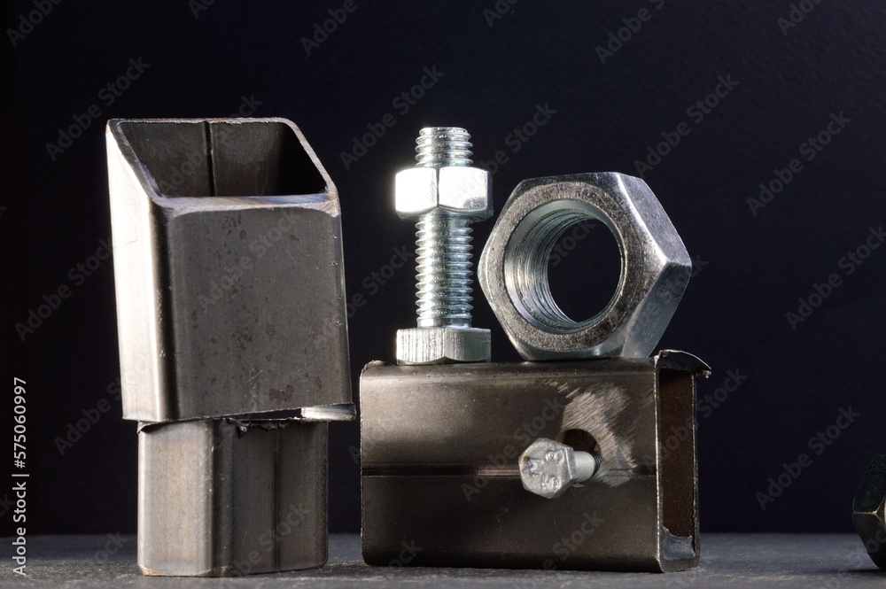 composition of nuts bolts and scraps of metal laid out on a dark background. composition of nuts bolts and scraps of metal laid out on a dark background.