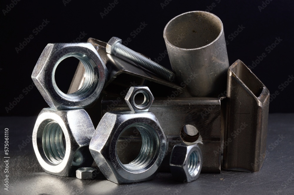 composition of nuts bolts and scraps of metal laid out on a dark background. composition of nuts bolts and scraps of metal laid out on a dark background.