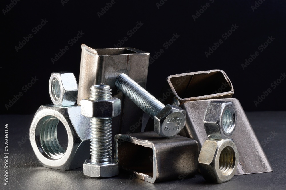 composition of nuts bolts and scraps of metal laid out on a dark background. composition of nuts bolts and scraps of metal laid out on a dark background.