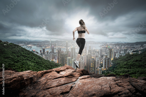 fitness girl running over hill far to the city