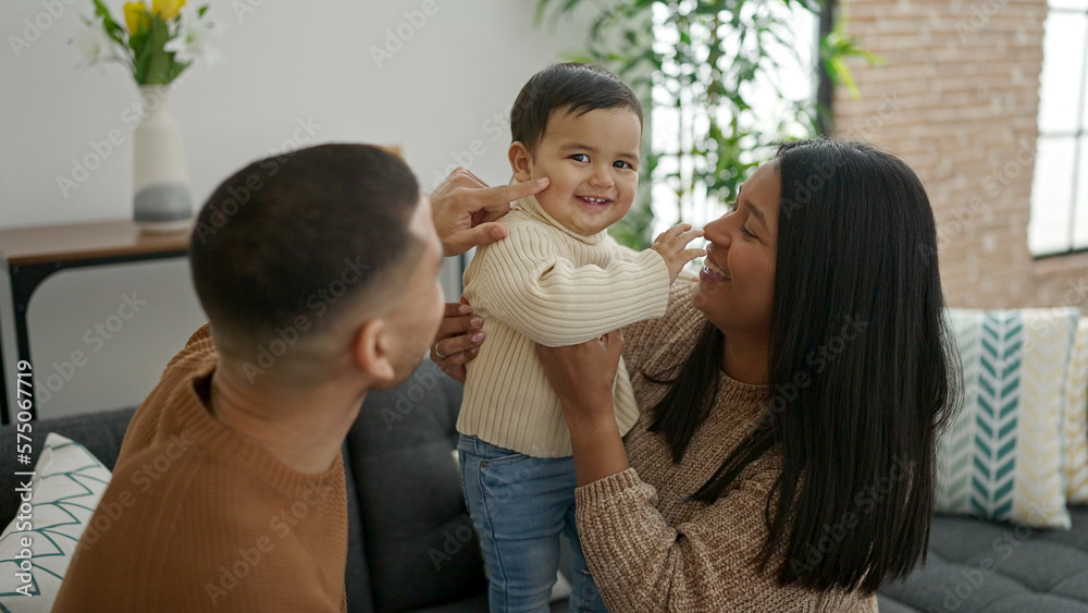 Couple and son hugging each other sitting on sofa at home Couple and son hugging each other sitting on sofa at home