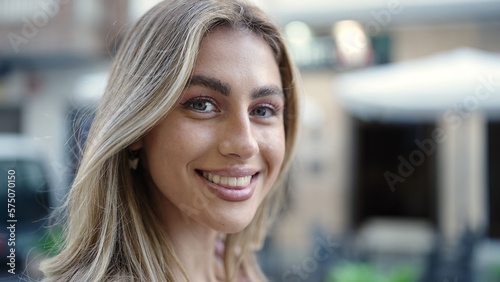 Young blonde woman smiling confident standing at street