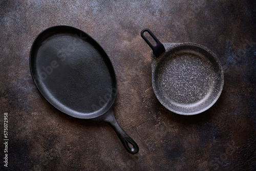 Two frying pans on a dark stone background close up, flat lay