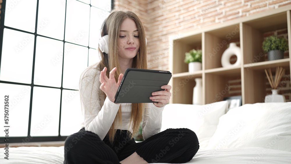 Young blonde woman watching video sitting on bed at bedroom Young blonde woman watching video sitting on bed at bedroom