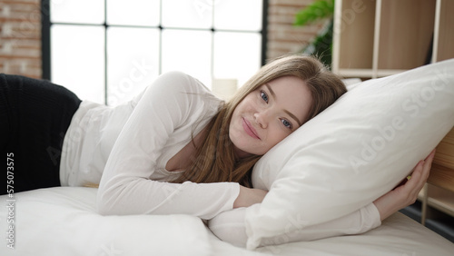 Young blonde woman smiling confident lying on bed at bedroom